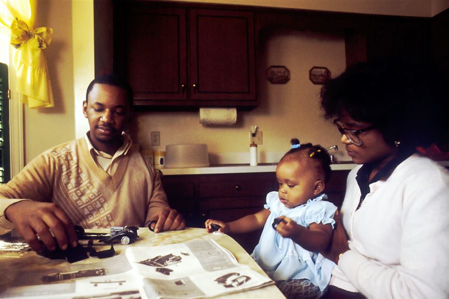 Parents with their baby going through papers at the kitchen table
